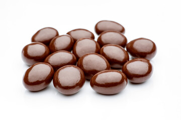 Chocolate raisins covered with milk chocolate lying on white background