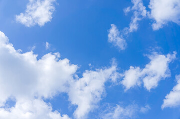 Captivating photo capturing the vastness and beauty of a bright blue sky adorned with fluffy white clouds.