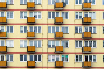 Old obsolete block building with yellow balconies. Soviet architecture in Europe, poor living conditions