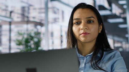 Smiling indian general manager focused on business operations, reviewing a project brief in order to ensure progress and achieve goals. Looking for solutions and resource allocation plans. Camera A.