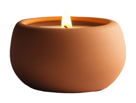 Lit candle in a terracotta holder against black background. Relaxation and warmth concept