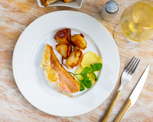 Gallineta fish fillet with sliced potatoes, served on dinner table
