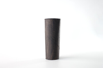 Recycled cardboard toilet paper roll tube, painted black, standing on a light surface. Step in creative process for crafting a penguin. Perfect for art supplies, DIY workshops, recycling initiatives