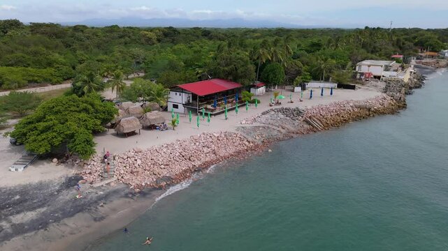 Aerial cinematographic view from a drone along the coast of Rio Hato with cloudy sunset, on the beach of Farallon in the Panamanian Pacific from Panama, 4K Video