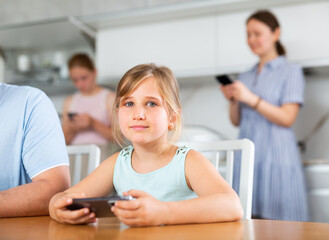 Fototapeta premium Portrait of happy children and parents using phones at home