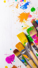 Fototapeta premium Colorful paintbrushes with vibrant paint splatters on white background for artistic design