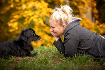 Chwile relaksu z psem - kobieta leży na trawie na przeciwko swojego psa  © nitka_zaplatana