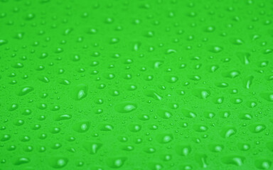 Green plastic with water drops macro photo.