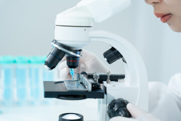 analyze biochemical samples in advanced scientific laboratory. Medical professional use microscope...