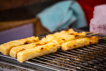 skewers of golden and tempting grilled rice cakes are neatly arranged on a grill