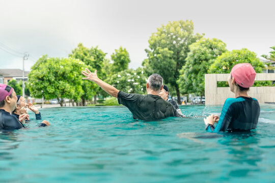 people enjoys a fun water activity in a swimming pool, playing a ball game with smiles and laughter. The scene emphasizes health, active living, and social engagement in an outdoor environment.