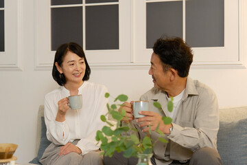 夜のリビングで会話する熟年夫婦