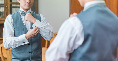 控え室・ブライズルームで結婚式・挙式・披露宴の準備をする新郎・花婿
