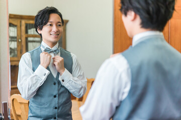 控え室・ブライズルームで結婚式・挙式・披露宴の準備をする新郎・花婿
