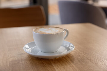 Cup of aromatic coffee on wooden table in cafe, closeup