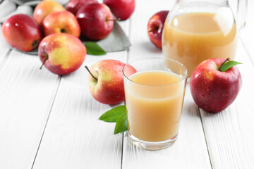 Refreshing apple juice and fruits on white wooden table