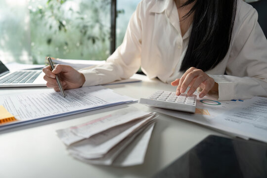 Person managing tax documents and checking information on a smartphone.