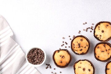 Delicious muffin with chocolate chips on light grey table, flat lay. Space for text