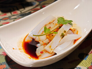 fresh cold rice jelly with soy sauce and green vegetables in the white bowl