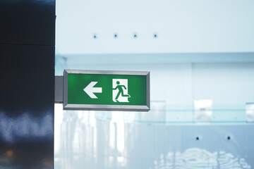 Exit sign directing towards the left in a modern indoor space