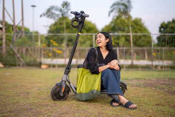 A woman is sitting on a scooter with a green bag on it