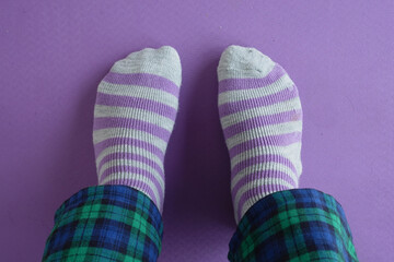 Cozy striped socks on a purple floor with plaid pants