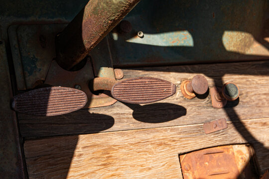 Foot pedals and controls on the floorboard of an antique Model T style truck.