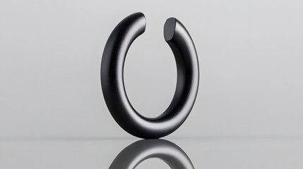 Obraz premium Matte Black Ring Magnet Placed on Reflective Background Minimalist Industrial Design Concept with Geometric Shapes and Metallic Textures