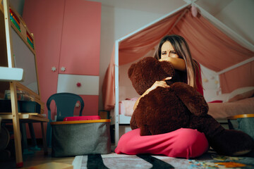 Sad Mother Crying Holding a Teddy Bear Toy Feeling Devastated. Depressed mother sharing tears for...