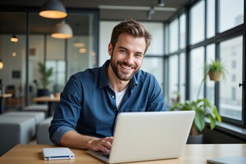 Fototapeta premium A Young Caucasian Male Professional in His 30s Working on a Laptop in a Bright, Modern Office Environment with Plants and Natural Light