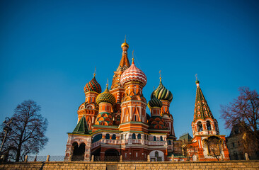Brightly colored onion domes of a historic Saint Basil’s cathedral stand out against a clear blue...