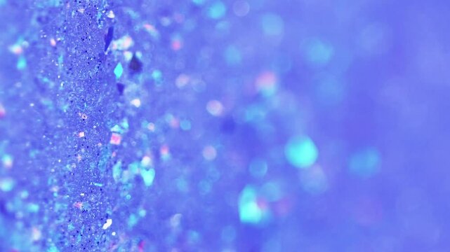 Vertical video. Sparkling paint flow. Wet glitter texture. Blur blue color shiny iridescent sequin particles paint fluid gel liquid motion abstract art background with bokeh lights.