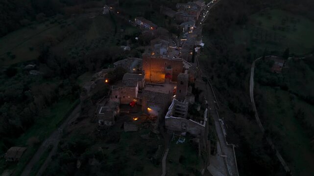 Aerial view of Celleno, a comune in the Province of Viterbo, Italy, featuring the ancient village illuminated at dusk