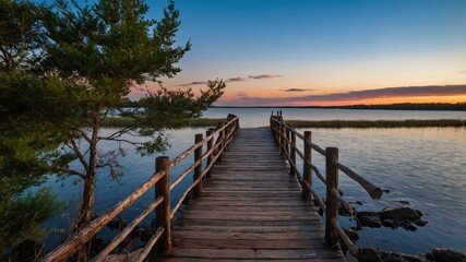 Obraz premium Scenic Wooden Bridge Over Calm Waters at Sunset with Distant Horizon and Lush Greenery Environmental Bliss