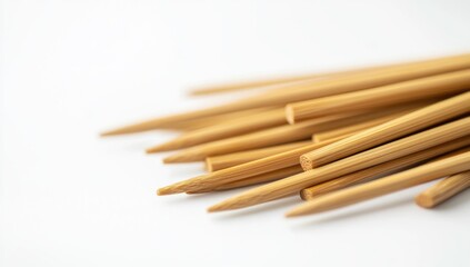 Obraz premium A pile of bamboo knitting needles on a white background, close-up