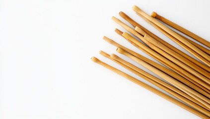 A pile of bamboo knitting needles on a white background, close-up
