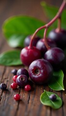 Close-up of fresh acai berries with leaves on wooden background, tropical, antioxidant, nutrition