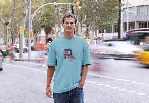 Stylish man in a short sleeve t-shirt poses confidently on a busy street in Barcelona during a sunny day. Mockup ready to use