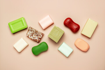 Assortment of colorful toilet moisturizing soap on pink background. Soft light, top view