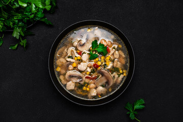 Spicy soup with chicken, mushrooms, corn, white beans, chili and cilantro. White background, top view
