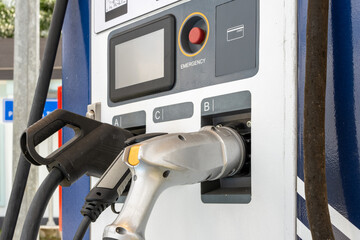 A modern EV charging station with multiple connectors, including CCS and Type 2 plugs. The charger...