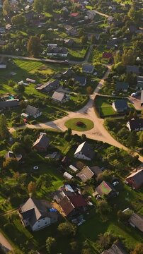 Aerial Drone Rotating Over A Small Roundabout Traffic Circle In Augsligatne Latvia.