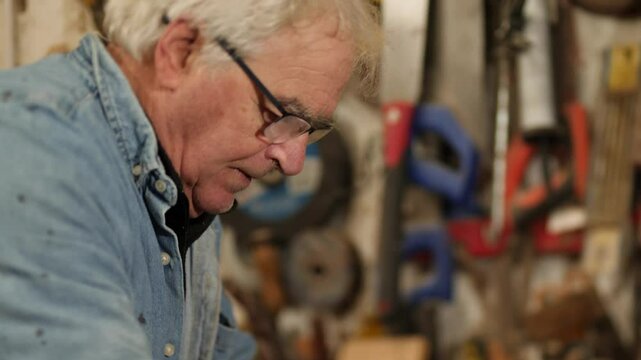 Senior carpenter crafting a smooth surface on a piece of iroko timber