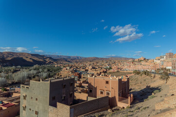 Town in Boulmalne Dades, Morocco surrounded by the desert and hills under blue sky