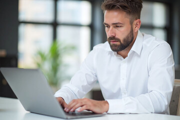 Fototapeta premium man sitting at a desk using a laptop computer