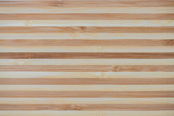 Bamboo board striped texture. Surface of flat bamboo board composed of alternating planks of of light and dark tones, pattern, background, close-up, high resolution.