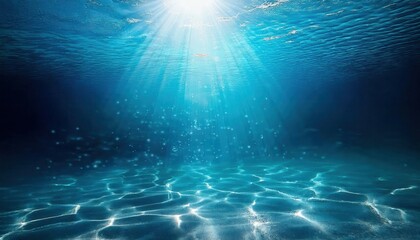Fototapeta premium sunlit underwater ocean scene with sandy seabed, shimmering light rays, and a school of fish in the deep blue sea