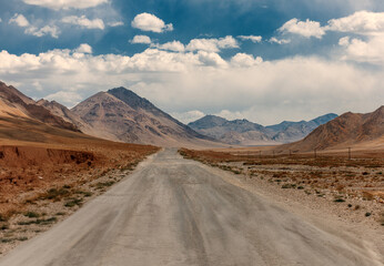 A road in the desert with mountains in the background