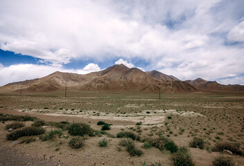 A barren desert landscape with a mountain in the background