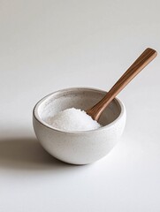 An elegant ceramic salt cellar with a spoon, featuring a smooth texture and refined design, ideal for stylish kitchen decor and functional dining presentations against a white backdrop.
